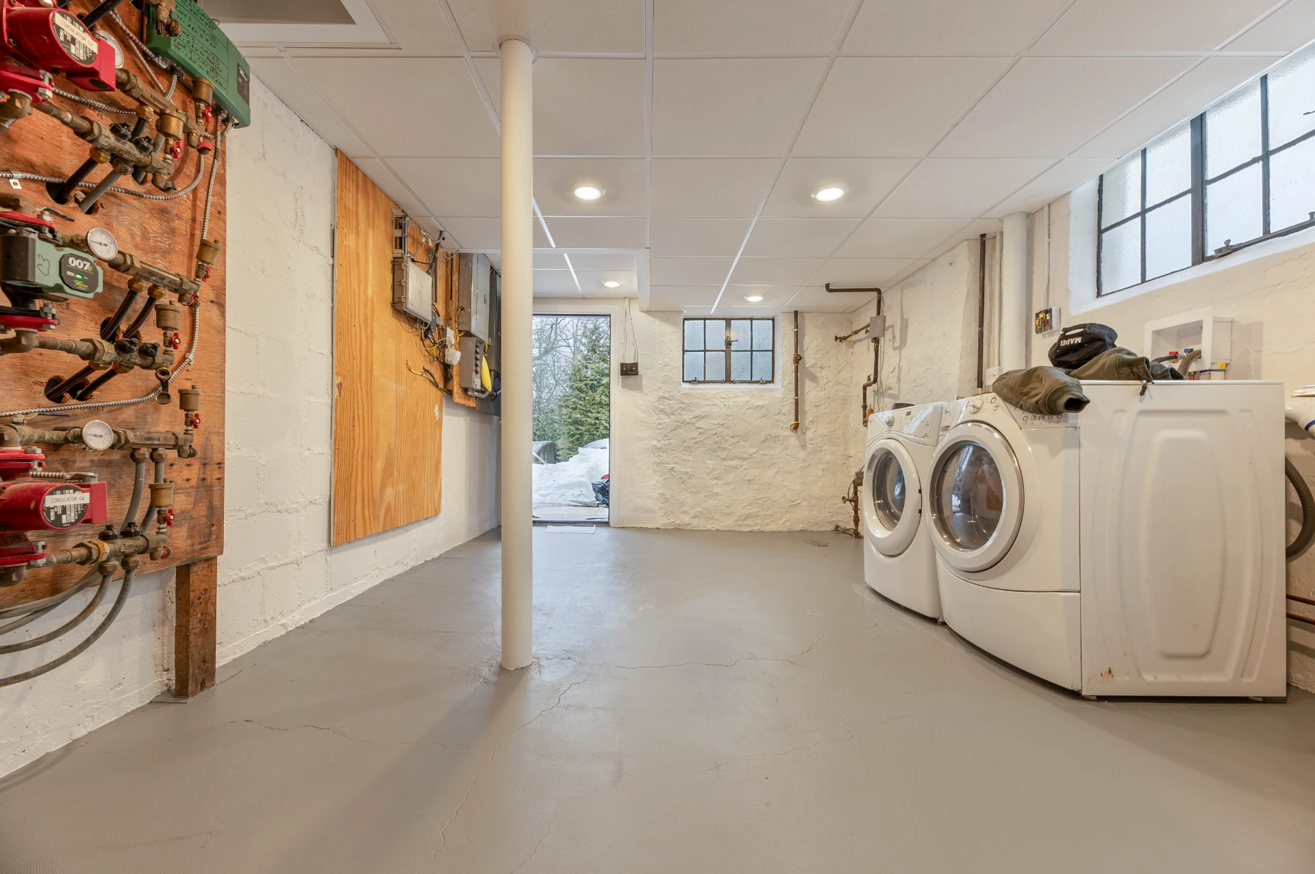 After: the same basement finished with painted brick and a new ceiling