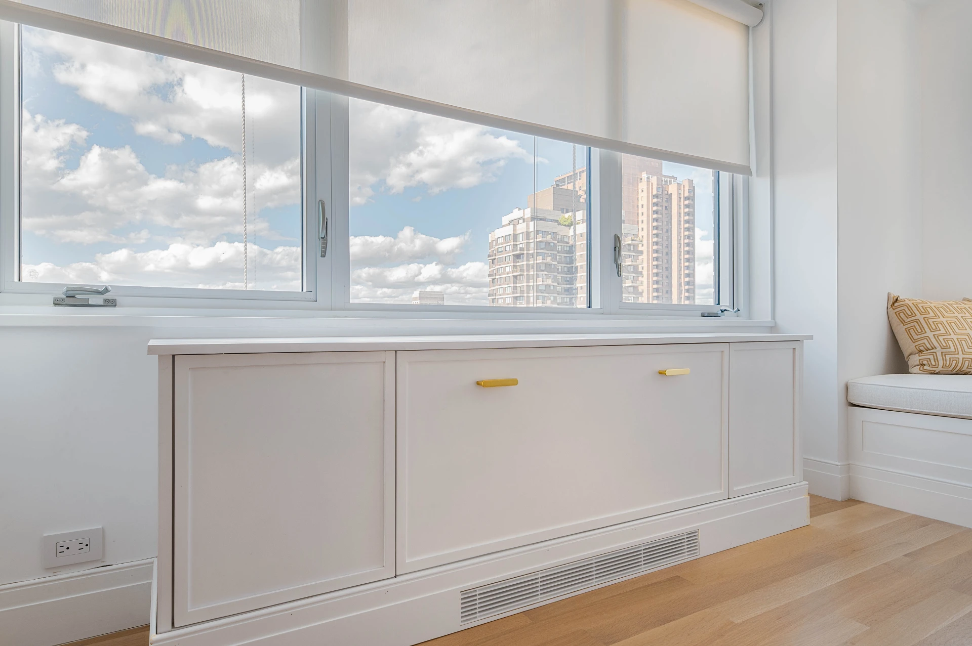 Long run of custom radiator cabinetry under a wall of windows