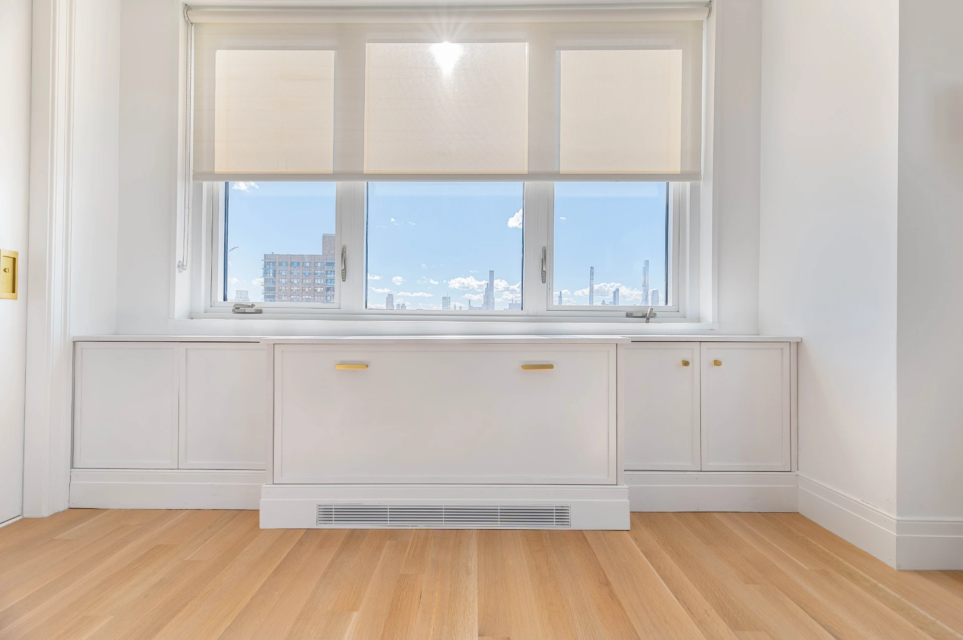 Custom cabinetry built in under a window, wide view of the finished room