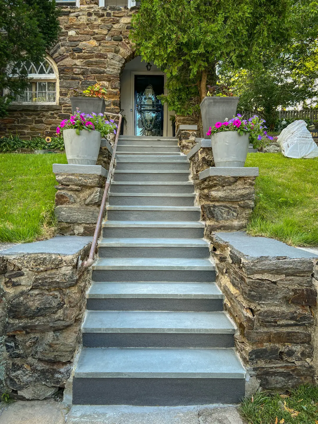 Finished bluestone staircase with stone piers and planted urns