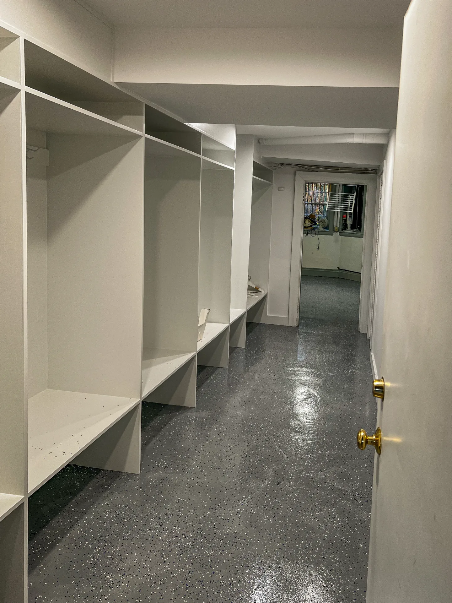 Built in white shelving units running along a corridor
