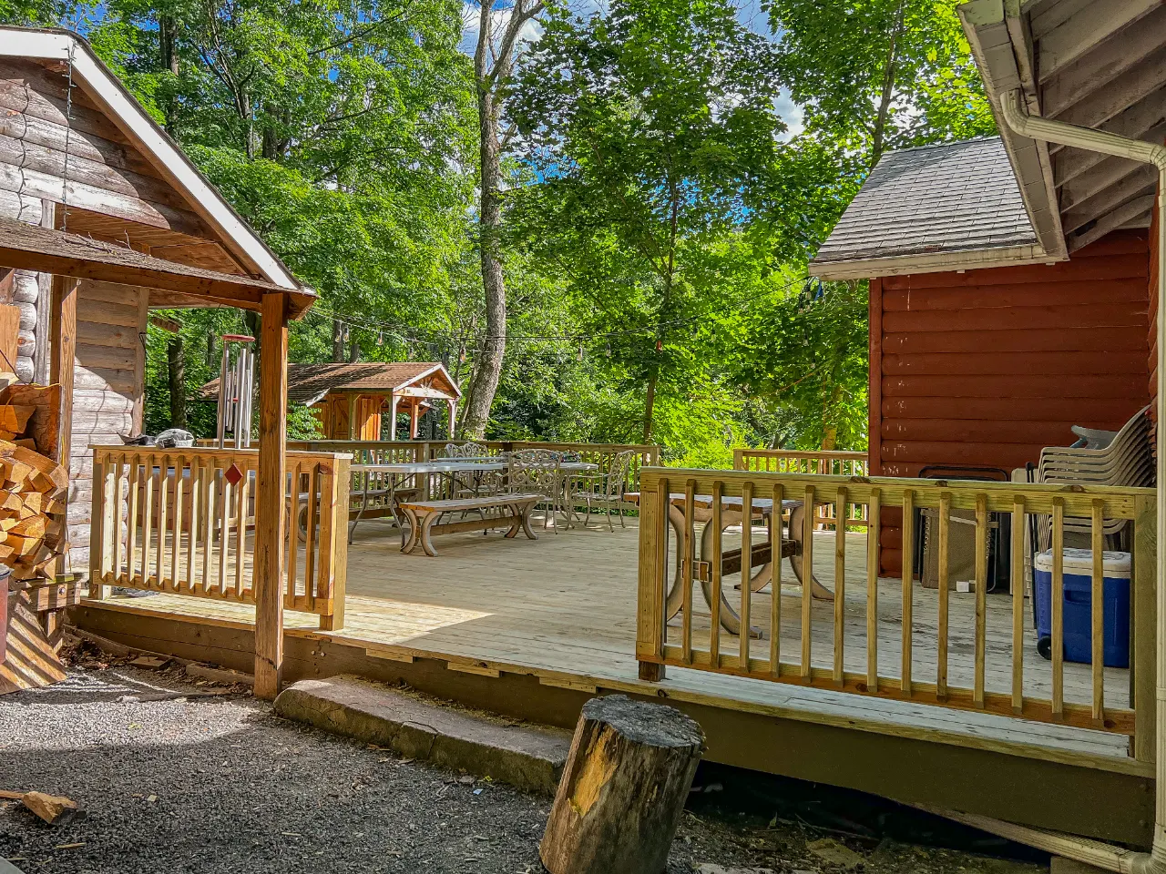 Finished deck with a wood railing at a log cabin in the woods
