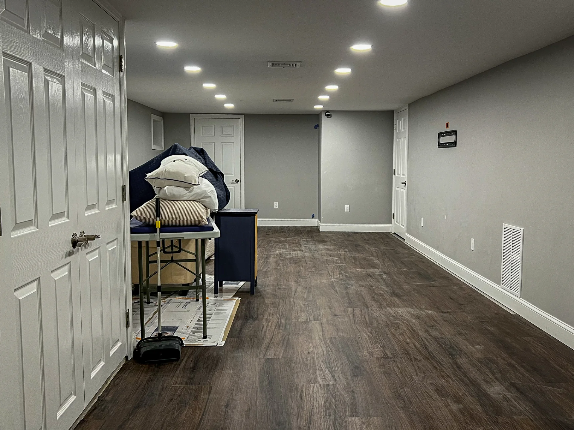 Finished basement with dark plank flooring and recessed lighting