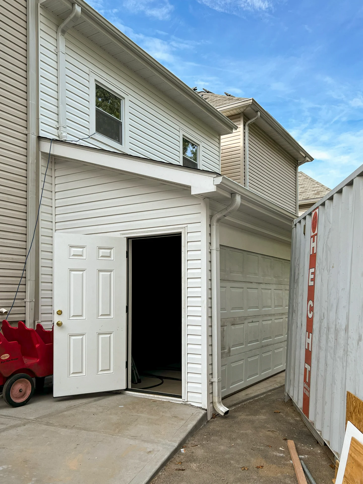 Exterior addition with new siding under a clear sky