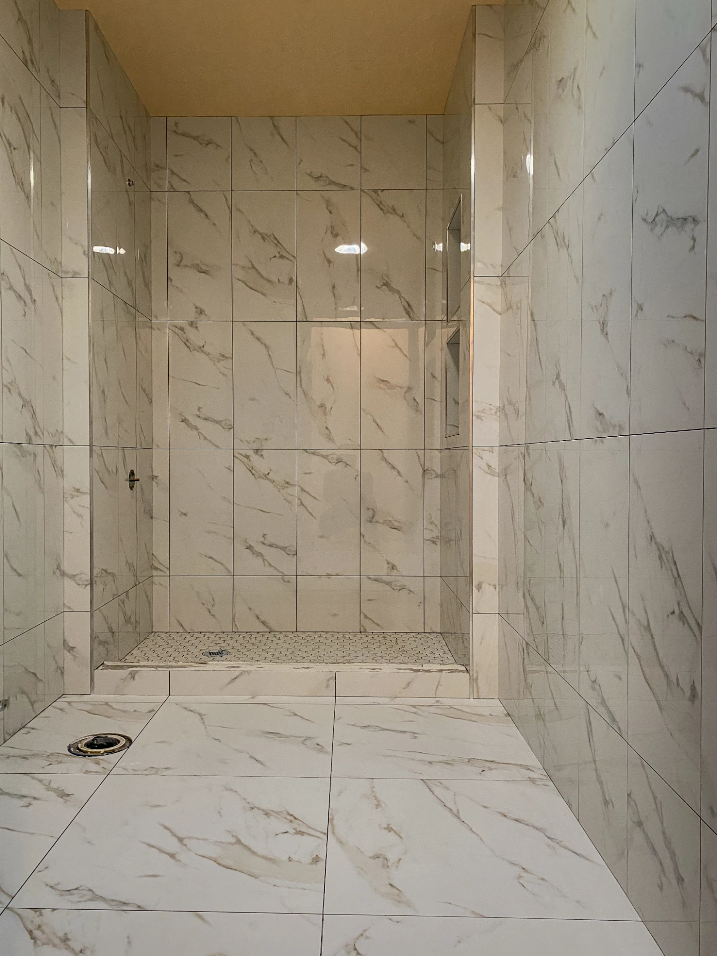 Finished shower in large format marble look porcelain tile